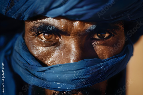 Close-Up Portrait of a Tuareg Man from the Sahara Desert: Traditional Blue Attire in High Contrast - Capturing the Essence and Culture of the Nomadic Life in a Vivid and Striking Expression. photo