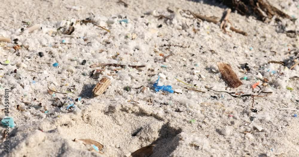 Microplastic pollution on beach sand highlighting environmental issues Microplastic pollution on beach sand highlighting environmental issues