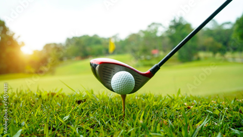 Golf ball and golf club in a beautiful golf course at sunset background.