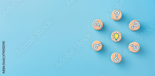 Wooden cubes with light bulb and question marks icons, copy space
