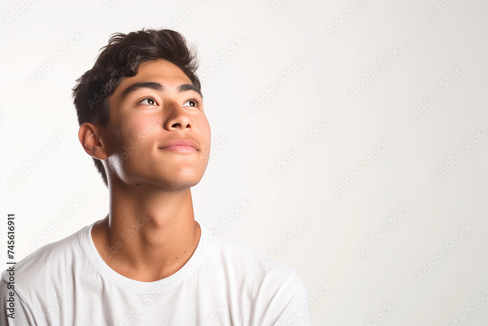 A young man, dressed in a simple t-shirt, looking upward with hope. A young man, dressed in a simple t-shirt, looking upward with hope.