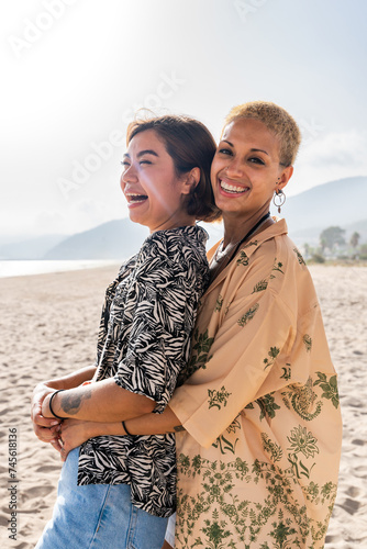 Beautiful multiethnic lesbian couple of lovers dating outdoors - LGBT people bonding and spending time together, concepts about LGBTQ community, diversity, love and lifestyle