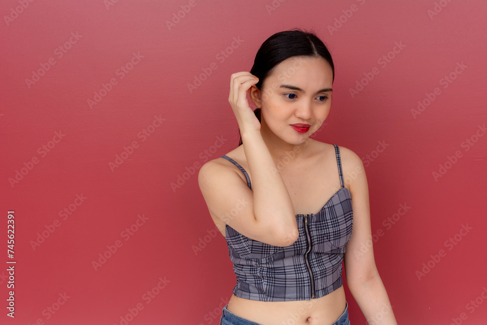 An insecure young asian woman looks concerned looking down. Feeling conscious about her looks. An insecure young asian woman looks concerned looking down. Feeling conscious about her looks.