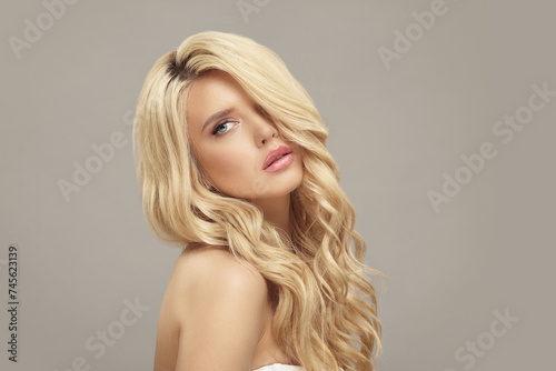 Blonde european woman with curly hair, beauty model on beige isolated
