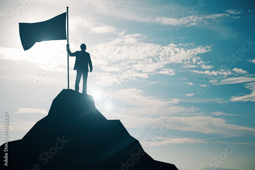 Bild auf Leinwand Person holding a flag on top of a mountain peak silhouetted against the sky, sym