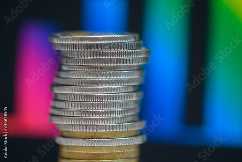 Stos monet ułożony na ciemnym tle, kolorowy wykres słupkowy 