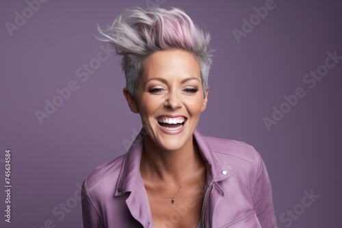 Closeup portrait of happy young woman with pink hair. Isolated on purple background
