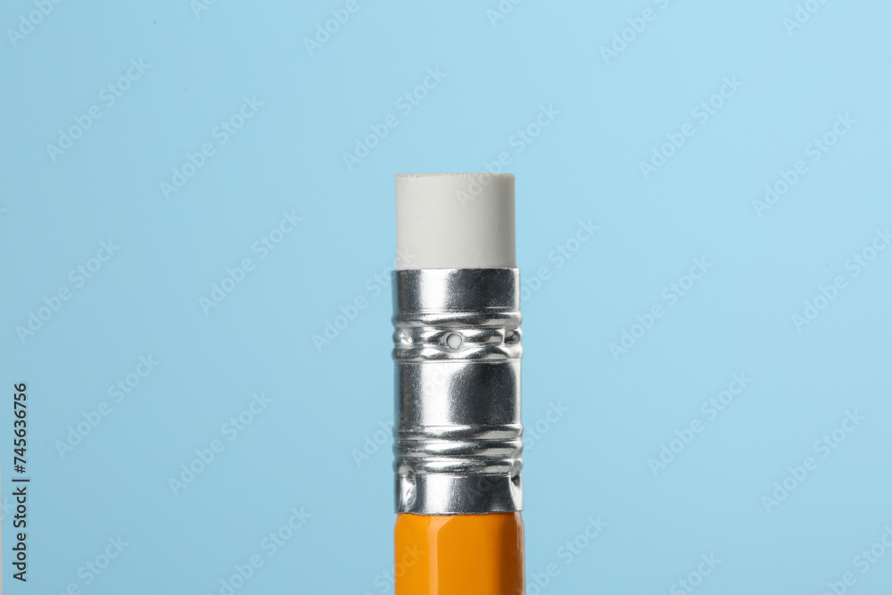 Graphite pencil with eraser on turquoise background, macro view Graphite pencil with eraser on turquoise background, macro view