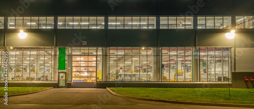 Warehouse facade at night, view of the illuminated warehouse through the windows