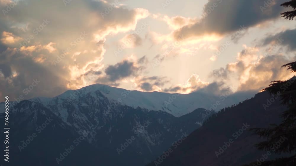 Orange clouds above the snow covered Himalayan mountains during the sunset at Manali in Himachal Pradesh, India. Orange clouds above the snowy mountains after sunset, Natural sunset in Himalayas. Orange clouds above the snow covered Himalayan mountains during the sunset at Manali in Himachal Pradesh, India. Orange clouds above the snowy mountains after sunset, Natural sunset in Himalayas.