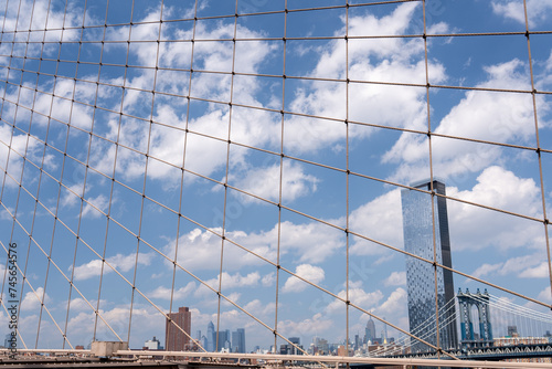 One Manhattan Square, a skyscraper in New York City, next to the Manhattan Bridge, with a cloudy sky in the background photo