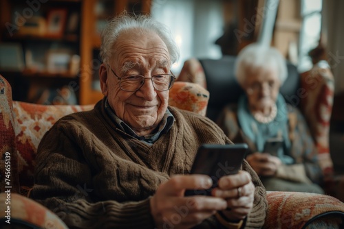 Elderly Man Using Smartphone at Home with Elderly Woman in Background