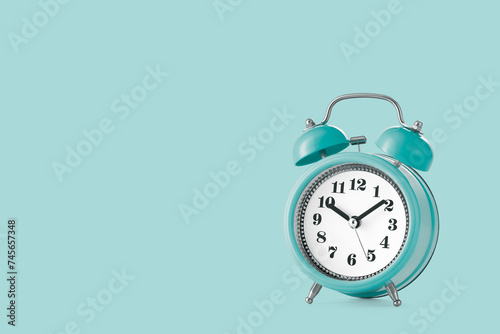 Alarm clock in the old style on a plain background with copy space. Low angle view. Studio shot.