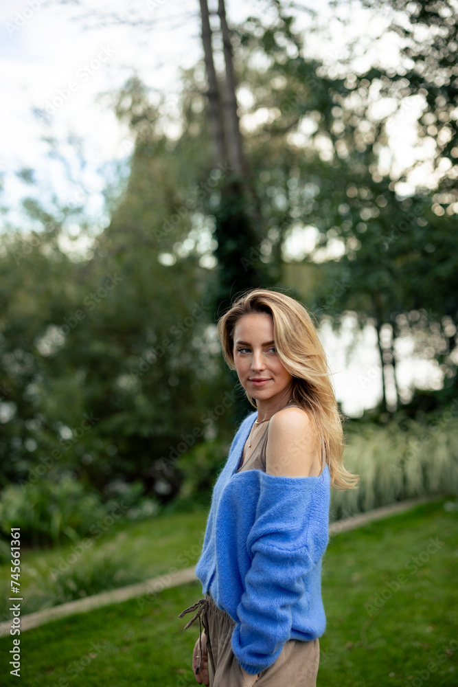 Smiling woman with blond hair standing in garden Smiling woman with blond hair standing in garden