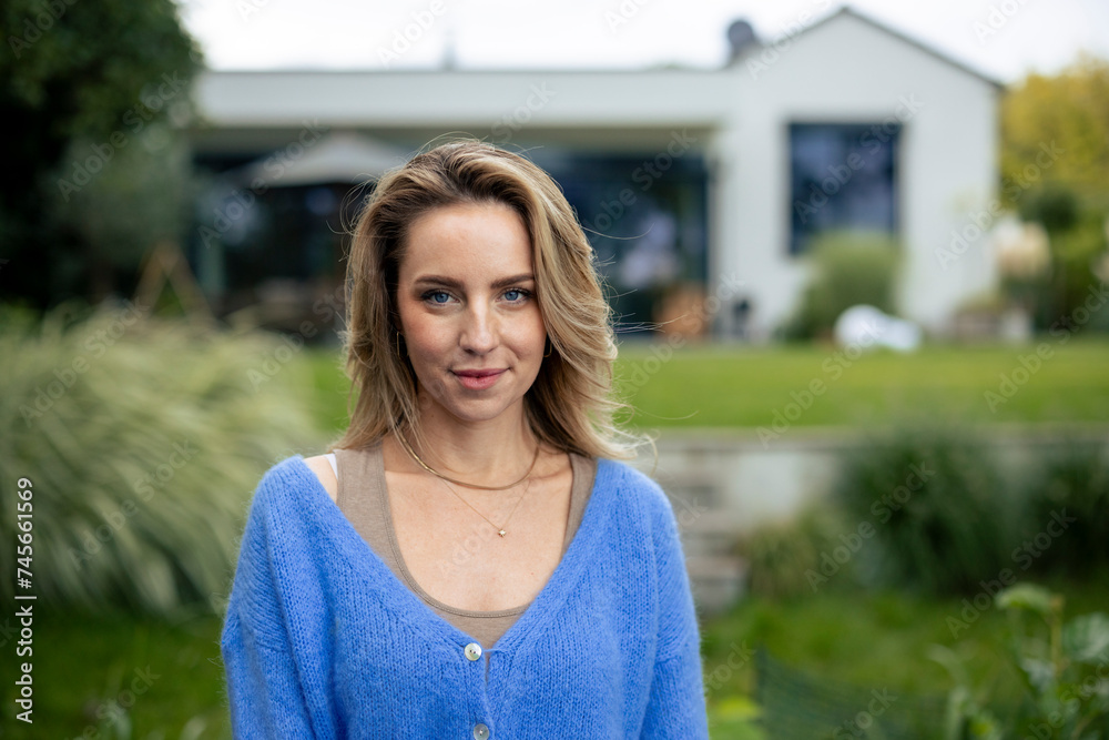 Smiling woman standing in front of house Smiling woman standing in front of house