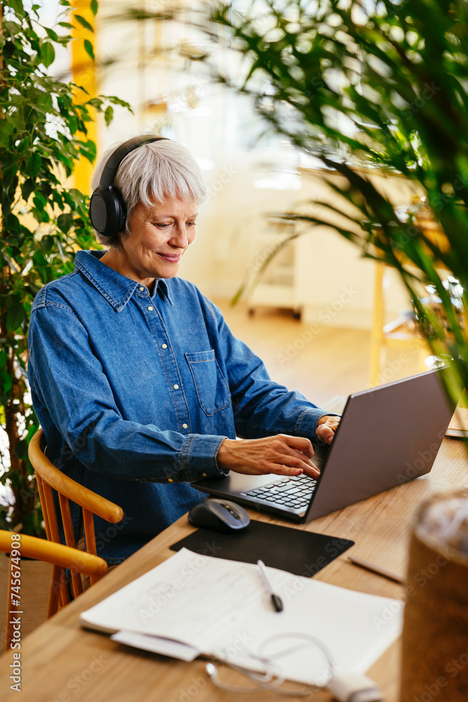 Smiling freelancer typing on laptop at home office