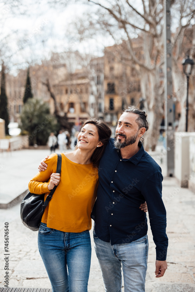 Happy couple walking on footpath and exploring city