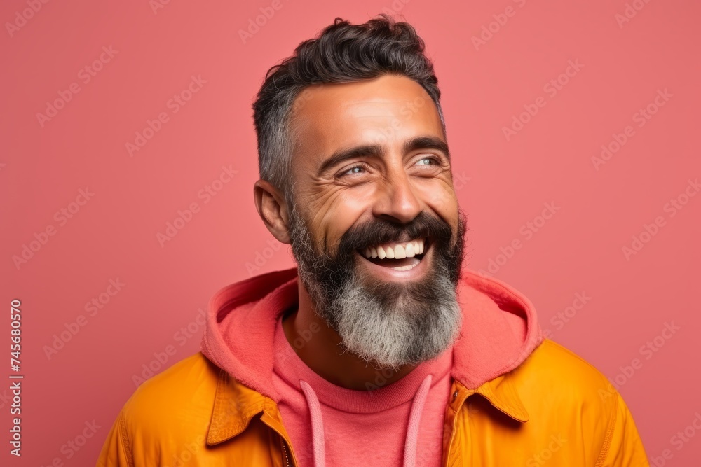 Portrait of happy bearded man laughing and looking at camera. Isolated on pink background Portrait of happy bearded man laughing and looking at camera. Isolated on pink background