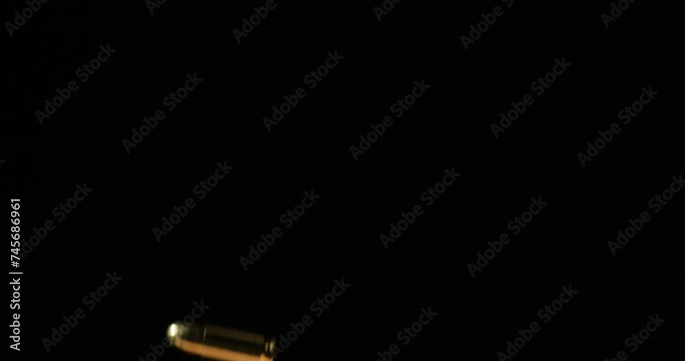 Bullets falling in slow motion in front of black background, static close up Bullets falling in slow motion in front of black background, static close up