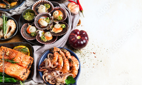 Set of Seafood dishes on light wooden background.