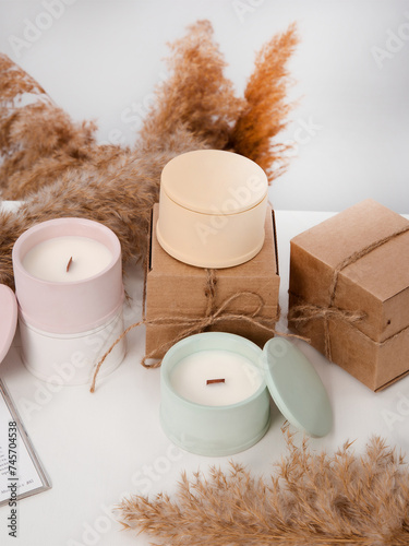 Cozy set of candles with lids surrounded by boxes