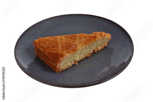 Portion triangulaire de gâteau traditionnel breton dans une assiette en gros plan sur fond blanc. photo
