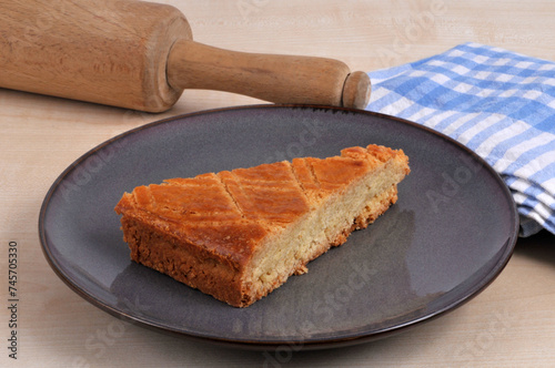 Portion de gâteau traditionnel breton dans une assiette avec un rouleau à pâtisserie et un torchon en gros plan photo