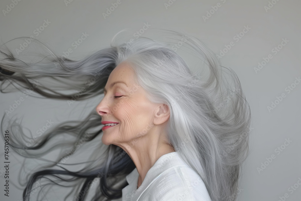 beautiful elderly woman model with beautiful gray hair smiling in the studio isolated on background. copy space
