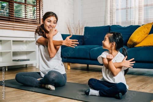 A mother and her daughter find joy in their family fitness journey at the gym where they focus on stretching and yoga fostering togetherness strength and happiness both exuding joy.