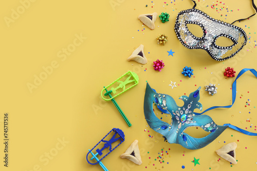 Purim celebration concept (jewish carnival holiday). Hamantaschen cookies over yellow background © tomertu