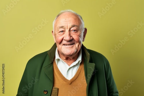 Portrait of a happy senior man in a green jacket on a green background
