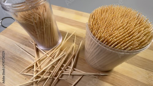 Wood toothpicks in plastic containers and scattered beside, selective focus photo