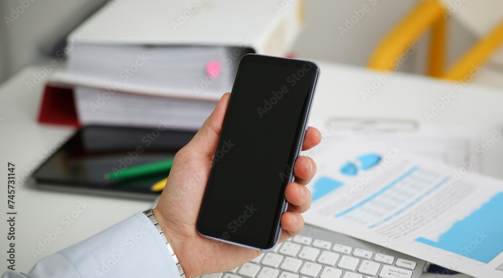 A businessman holds a new smartphone in