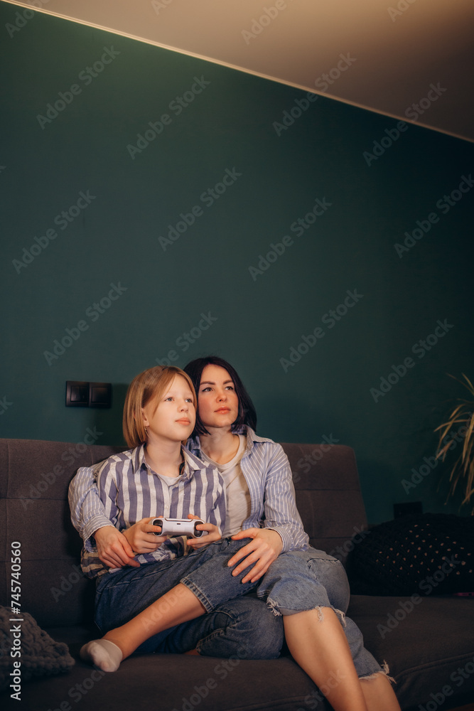 Mother and daughter playing video games. Home leisure lifestyle. Mother and daughter playing video games. Home leisure lifestyle.