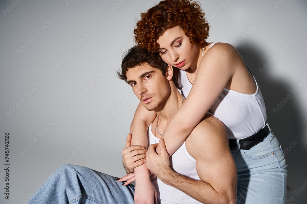pretty woman sitting on floor and hugging her appealing boyfriend who looking at camera, sexy couple pretty woman sitting on floor and hugging her appealing boyfriend who looking at camera, sexy couple