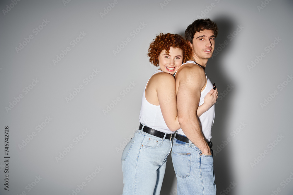 joyful appealing couple in cozy blue jeans hugging warmly and smiling at camera, sexy couple joyful appealing couple in cozy blue jeans hugging warmly and smiling at camera, sexy couple