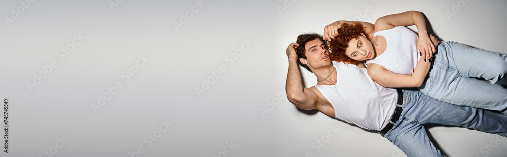 handsome man lying on floor next to his young girlfriend and looking at camera, sexy couple, banner handsome man lying on floor next to his young girlfriend and looking at camera, sexy couple, banner