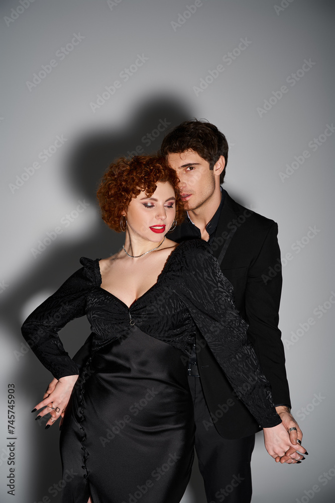 attractive man in suit looking at camera while hugging his alluring girlfriend, sexy couple attractive man in suit looking at camera while hugging his alluring girlfriend, sexy couple