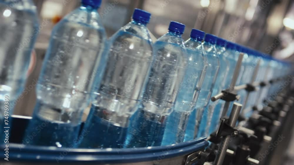 No people Dutch angle footage of row of bottles with still or table water moving on conveyor at bottled water manufacturing plant