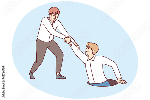 Man saves friend fell into hatch in ground, extending helping hand in difficult situation. Young businessman helps out partner after economic problems or crisis