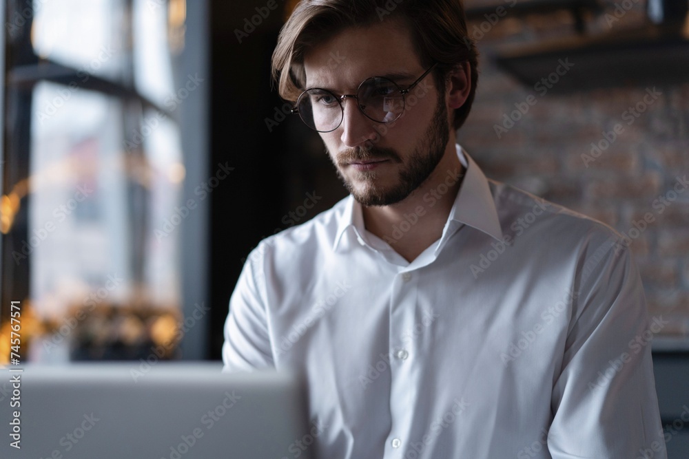 Business portrait - businessman sitting in in office working with laptop computer. Middle age man in 30s with happy confident smile Business portrait - businessman sitting in in office working with laptop computer. Middle age man in 30s with happy confident smile