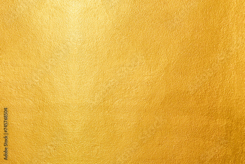 Gold wall texture background. Yellow shiny gold paint on wall surface with light reflection, vibrant golden luxury wallpaper sheet