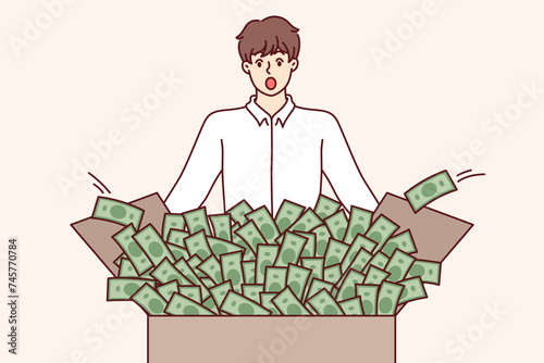 Shocked man looks at box full of money, surprised to get big profit from investing in stock market. Lucky guy won lot of money in national lottery or new betting app for mobile phone
