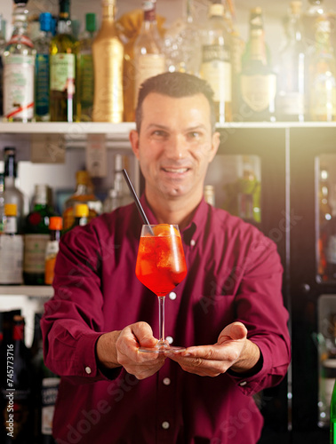 Bartender presenting cocktail at bar