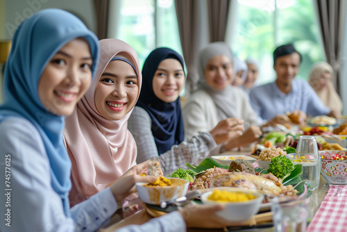 Happy Asian muslim family online greeting celebrate long distance with cousin looking at camera video call Ramadan dinner together at home 