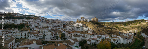 Panoramic view over andalusian village with white houses and street with dwellings built into rock overhangs, Setenil de las Bodegas, Andalusia, Spain