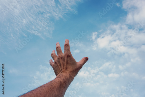 man hand gesturing on the blue sky