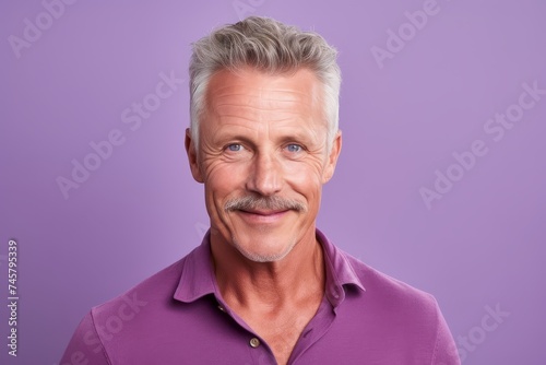 Portrait of handsome mature man. Isolated on violet background.