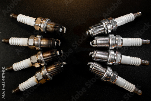 Old and New Spark plugs on black background . car and motorcycle part. The concept of car service, repair. Top down view.