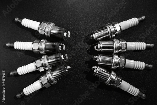 Old and New Spark plugs on black background . car and motorcycle part. The concept of car service, repair. Top down view. Black and white